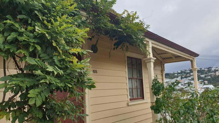 Exterior shot of the cream-coloured Nairn Street Cottage, a heritage home and museum.